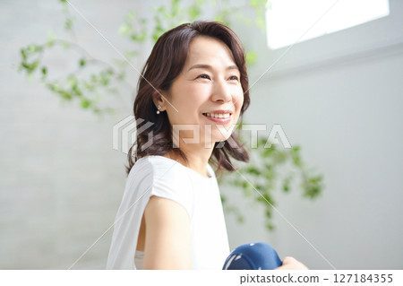 一位 50 多歲的女性穿著瑜伽服做瑜伽 127184355