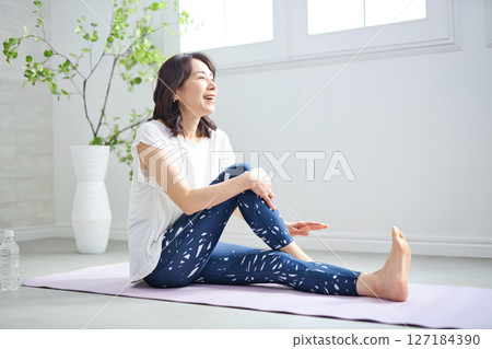 一位 50 多歲的女性穿著瑜伽服做瑜伽 127184390