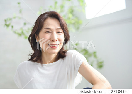 一位 50 多歲的女性穿著瑜伽服做瑜伽 127184391