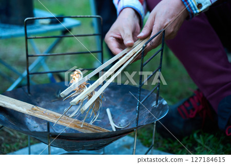 Solo camper making a fire, ignition, solo camping, senior Solo camper making a fire, ignition, solo camping, senior 127184615