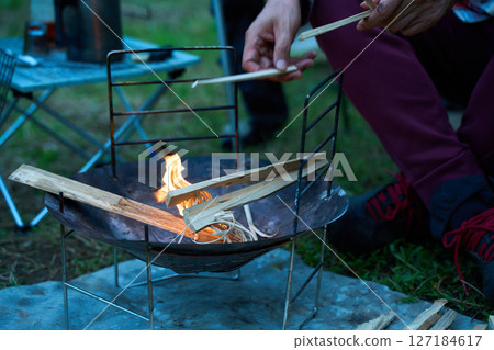 Solo camper making a fire, ignition, solo camping, senior Solo camper making a fire, ignition, solo camping, senior 127184617