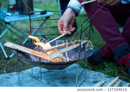 Solo camper making a fire, ignition, solo camping, senior Solo camper making a fire, ignition, solo camping, senior 127184618