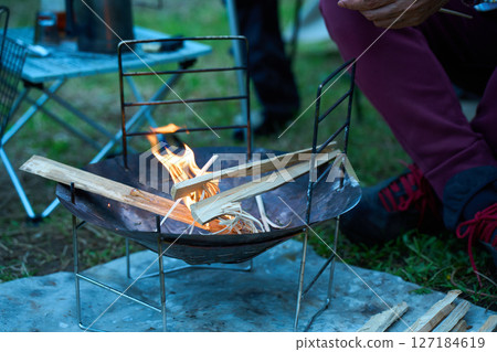 Solo camper making a fire, ignition, solo camping, senior Solo camper making a fire, ignition, solo camping, senior 127184619