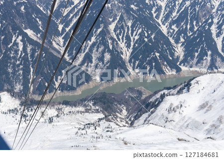 A beautiful winter view of Kurobe Dam and the majestic snow-covered mountains seen from near Kurobedaira Station on the Tateyama Ropeway A beautiful winter view of Kurobe Dam and the majestic snow-covered mountains seen from near Kurobedaira Station on the Tateyama Ropeway 127184681