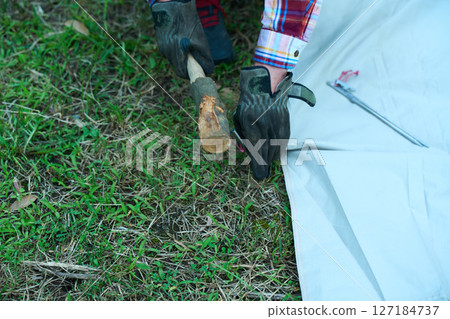 Solo camper setting up a tent, solo camping, senior 127184737