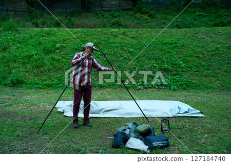 Solo camper setting up a tent, solo camping, senior Solo camper setting up a tent, solo camping, senior 127184740