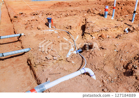 Workers are installing plumbing pipes drainage systems at construction site during work time hours. Workers are installing plumbing pipes drainage systems at construction site during work time hours. 127184889