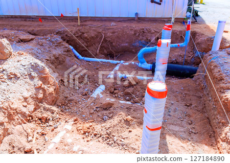 Workers are excavating trench for new plumbing lines in suburban construction site in works time 127184890