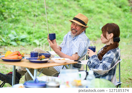 Mature couple camping outdoors barbecue BBQ family colleagues friends 127185374