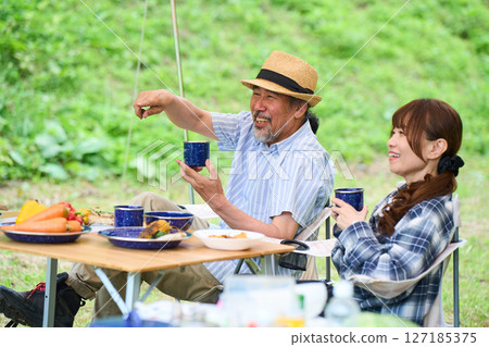Mature couple camping outdoors barbecue BBQ family colleagues friends 127185375