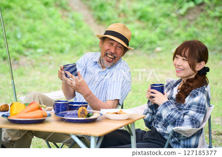 Mature couple camping outdoors barbecue BBQ family colleagues friends 127185377