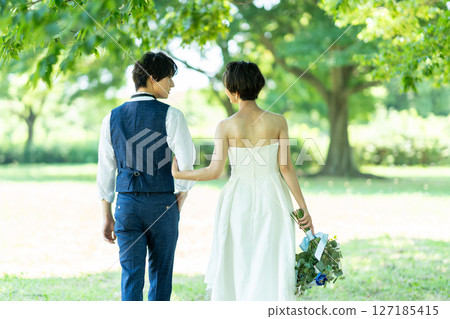 新娘和新郎手挽手散步的背影 127185415