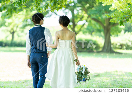 新娘和新郎手挽手散步的背影 127185416