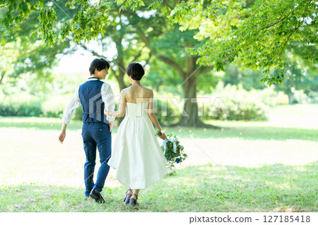 新娘和新郎手挽手散步的背影 127185418
