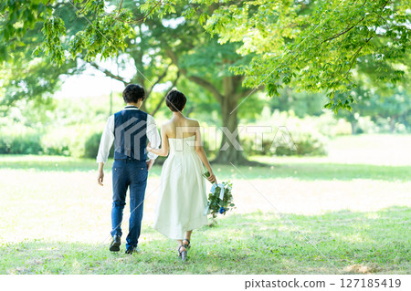 新娘和新郎手挽手散步的背影 127185419