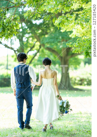 新娘和新郎手挽手散步的背影 127185420
