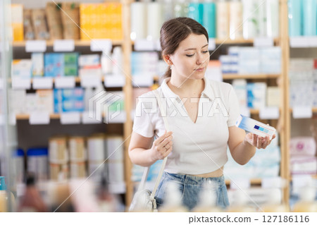 Female customer choosing therapeutic ointment in pharmacy Female customer choosing therapeutic ointment in pharmacy 127186116