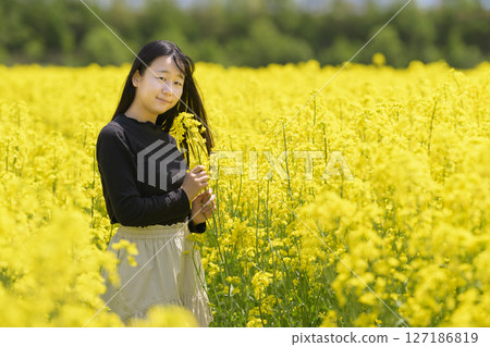 一名女子在盛開的油菜花田中觀光 127186819