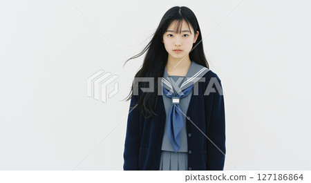 白色背景。身穿海軍藍羊毛衫、長髮飄逸的高中女生 127186864