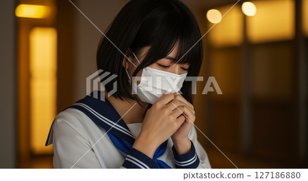 A high school girl in a sailor uniform coughing while wearing a mask outdoors at night A high school girl in a sailor uniform coughing while wearing a mask outdoors at night 127186880