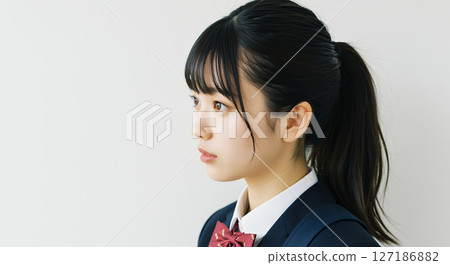 一名身穿西裝外套、綁著馬尾、指向左側的高中女生 127186882