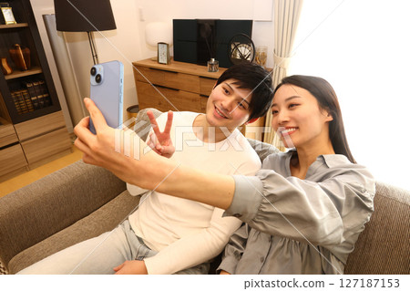 採取在長沙發的夫婦一selfie 127187153