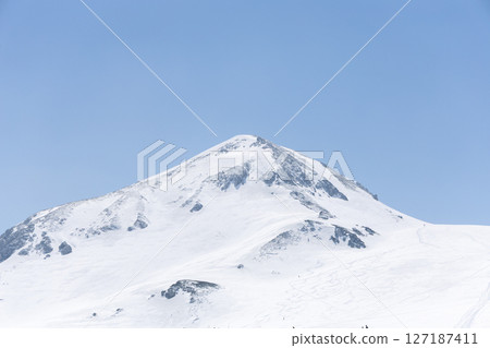 In the spring of April, the majestic snowscape of the pure white Tateyama mountain range spreads out majestically under the blue sky. 127187411