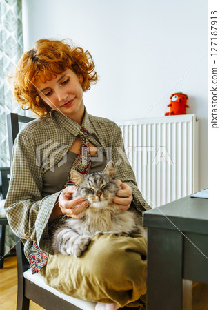 Portrait teenage girl with red hair and pet cat at home 127187913