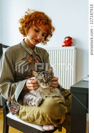 Portrait teenage girl with red hair and pet cat at home 127187918