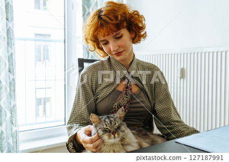 Portrait teenage girl with red hair and pet cat at home 127187991