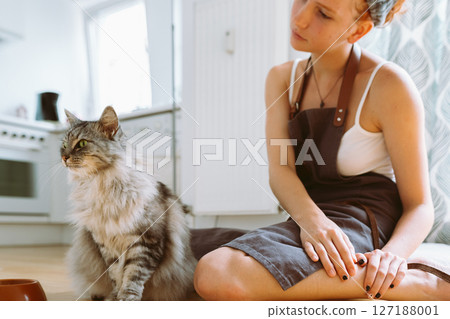 Caring for pet. teenage girl feeding domestic cat Caring for pet. teenage girl feeding domestic cat 127188001