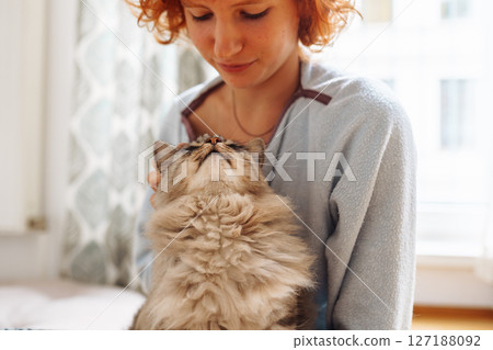 Portrait red-haired curly young woman with beloved fluffy domestic cat Portrait red-haired curly young woman with beloved fluffy domestic cat 127188092