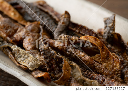 Salmon skin chips on a plate 127188217