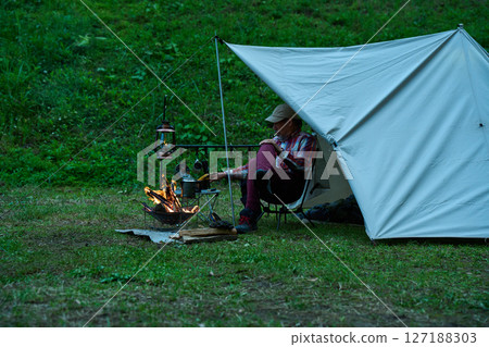 Solo camper boiling coffee, solo camping, senior 127188303