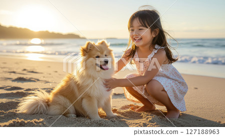 Smiling girl playing with dog on the beach 127188963