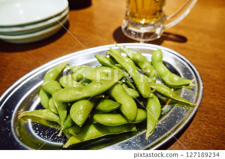 Chilled edamame and beer in an izakaya, close-up 127189234