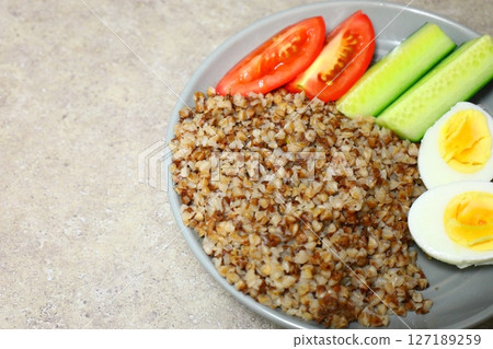 Buckwheat with boiled egg, cucumbers and tomatoes, breakfast Buckwheat with boiled egg, cucumbers and tomatoes, breakfast 127189259