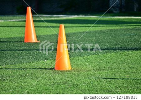 artificial green grass soccer field with orange training cones 127189813