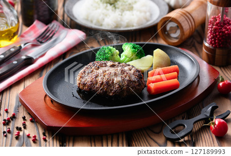Hot hamburger steak cooked on a hot iron plate Hot hamburger steak cooked on a hot iron plate 127189993