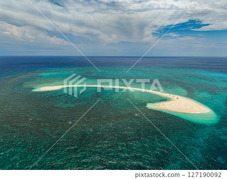 White island surrounded by azure sea water texture. Waves and corals reefs. Camiguin, Philippines. 127190092