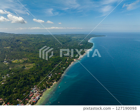 Tropical island with greenery forest and blue sea. Blue sky and clouds. Samal Island. Davao, Philippines. Tropical island with greenery forest and blue sea. Blue sky and clouds. Samal Island. Davao, Philippines. 127190098