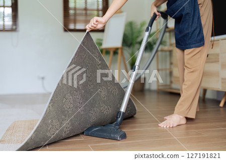 Beautiful young girl housekeeper cleaner wear apron and vacuuming messy dirty floor for housekeeping housework and chores in house 127191821