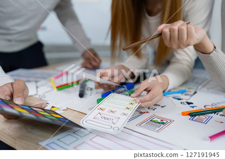 UI designer and UX developer brainstorm idea to design the application appearance in the early stage. Creative digital development agency. UX UI concept 127191945