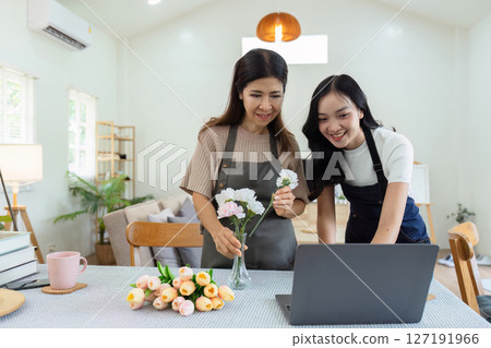 Mother and daughter arrange flower together at home on the weekend, family activities, mother and daughter do activities together on Mother's Day 127191966