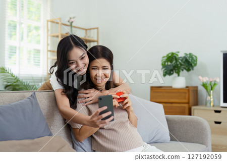 Congratulations. Loving asian mature daughter surprised mother with present in Mother's Day, giving her handmade card and gift box Congratulations. Loving asian mature daughter surprised mother with present in Mother's Day, giving her handmade card and gift box 127192059