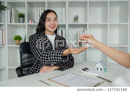 real estate agent give house key to client after successfully signing the contract document real estate agent give house key to client after successfully signing the contract document 127192168
