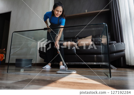 cleaning service housekeeper women swipe floor in living room. House cleaning service concept 127192284