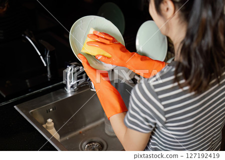 housewife cleans the house and washes the dishes at the sink. Cleaning home concept housewife cleans the house and washes the dishes at the sink. Cleaning home concept 127192419