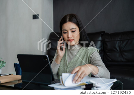 young asian business woman, freelance data accountant work from home, work remotely at home, talking with client on mobile young asian business woman, freelance data accountant work from home, work remotely at home, talking with client on mobile 127192420