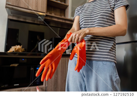 Female housekeeper smile and wearing glove, preparing to cleaning home Female housekeeper smile and wearing glove, preparing to cleaning home 127192510